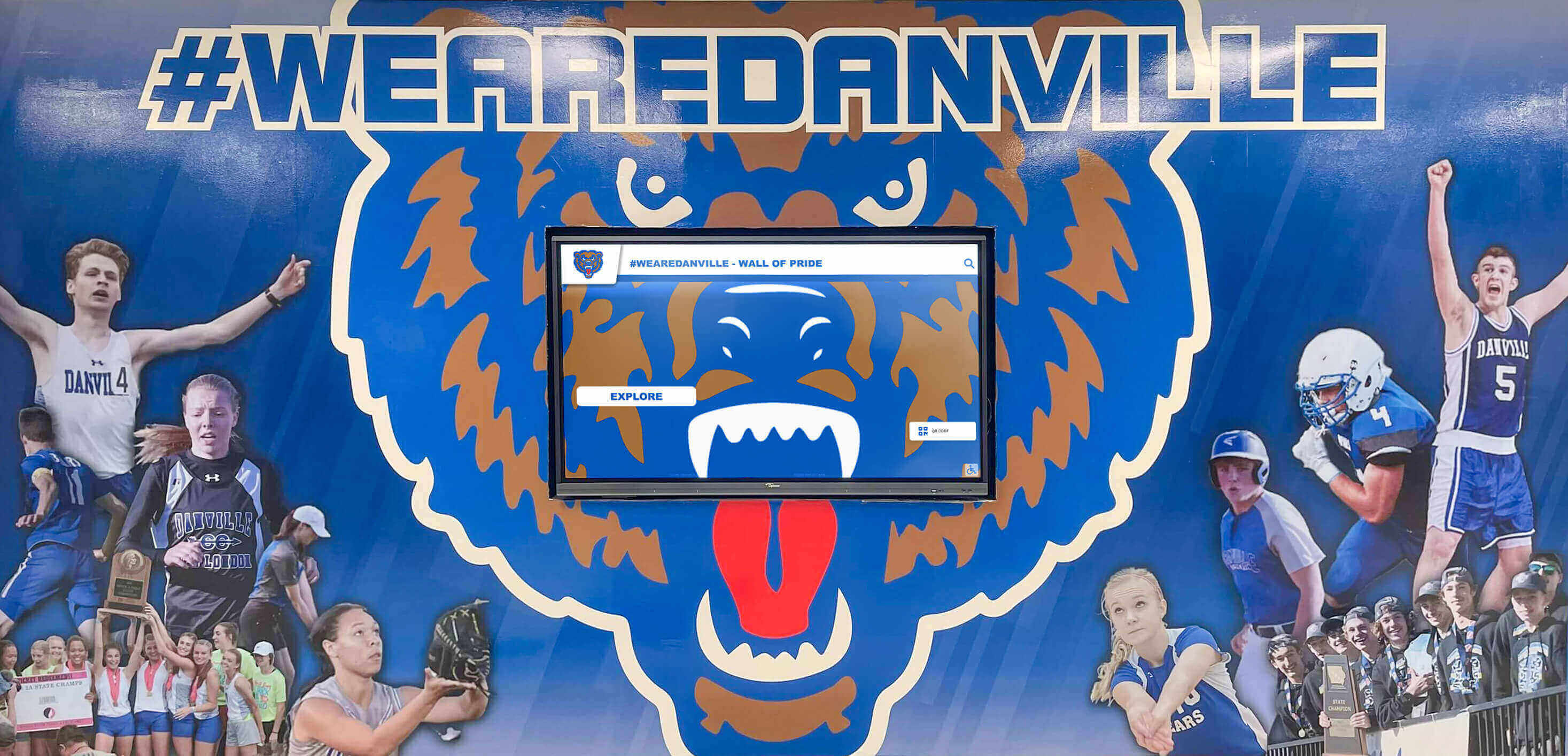 School athletic hallway with team mural and digital display
