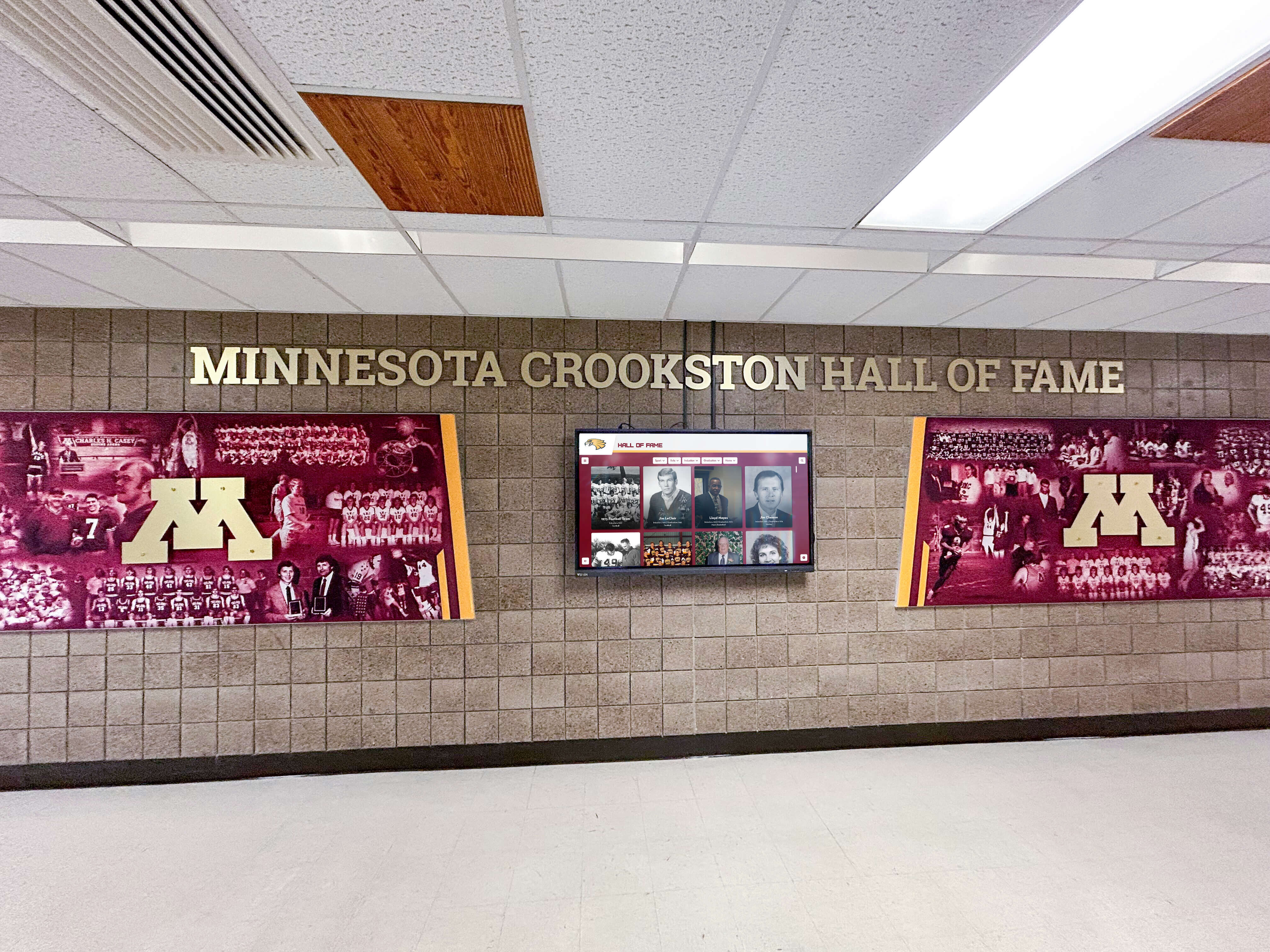 Minnesota Crookston Maroon Rockets hall of fame installation with digital screen display Minnesota Crookston hall of fame maroon murals with digital screen display